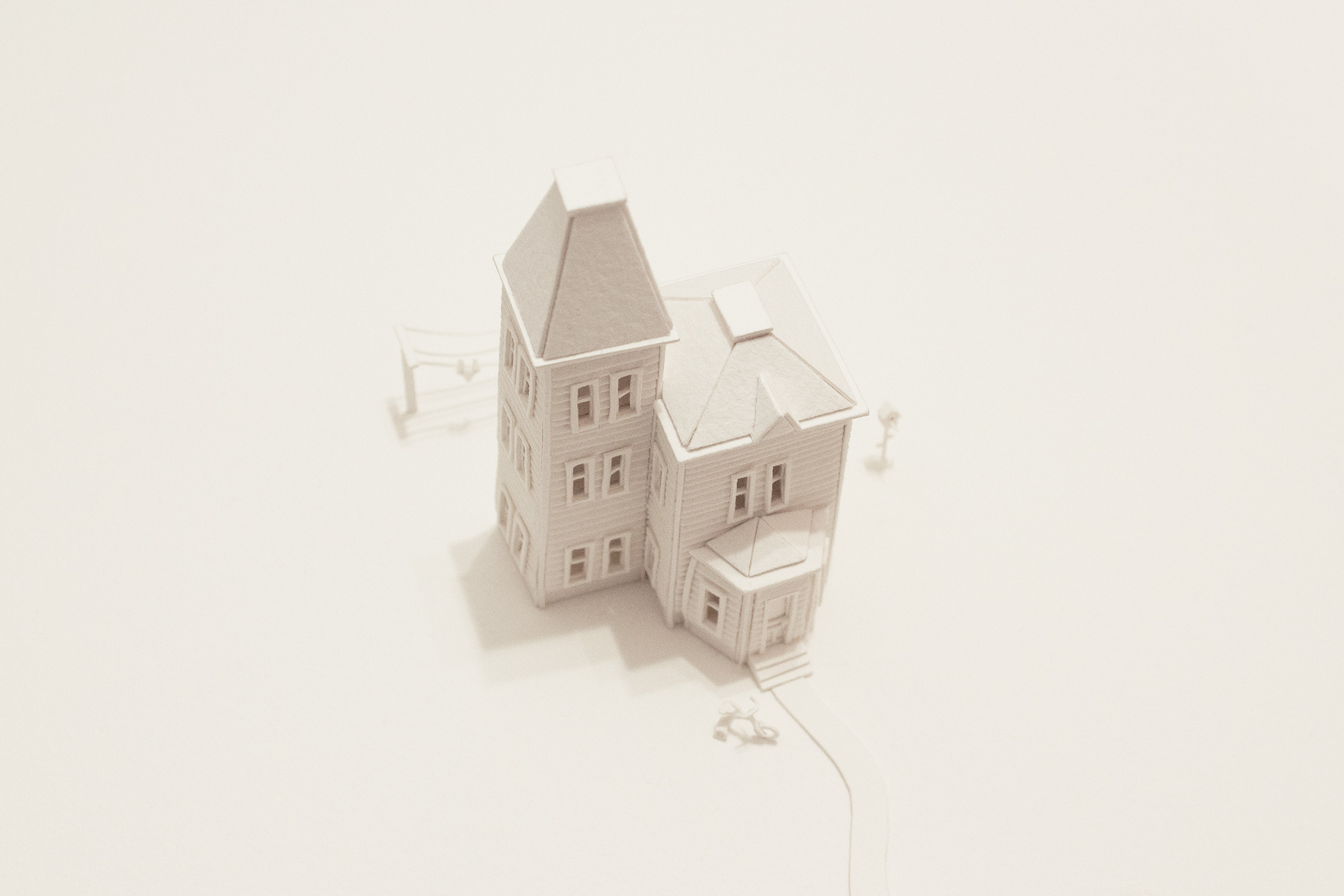 Photo illustration depicting a 3d house made of all white cut paper.
